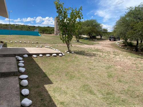 een park met een boom en stenen op het gras bij Lucero de Brochero in Villa Cura Brochero