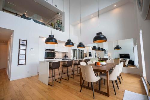 een keuken en eetkamer met een tafel en stoelen bij 403 - Luxury Condo - Incredible View & Pool in Baie-Saint-Paul