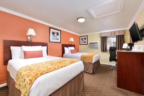 a hotel room with two beds and a flat screen tv at Cheshire Welcome Inn in Cheshire