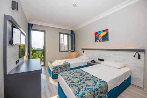 a hotel room with two beds and a window at Golden Moon Hotel in Fethiye