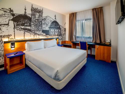een hotelkamer met een groot bed en een bureau bij Hotel Sercotel Plana Onda in Onda