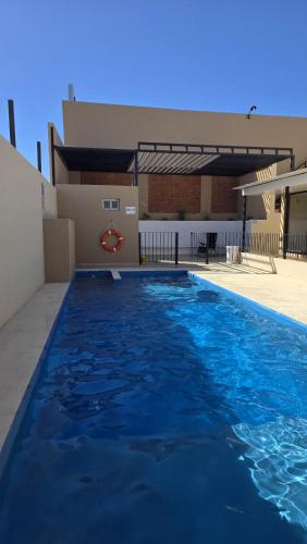 a large blue swimming pool in front of a building at Habitaciones Brisas Místicas in Las Grutas