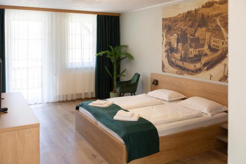 a bedroom with a bed and a painting on the wall at Pensiunea Draser in Şeica Mică