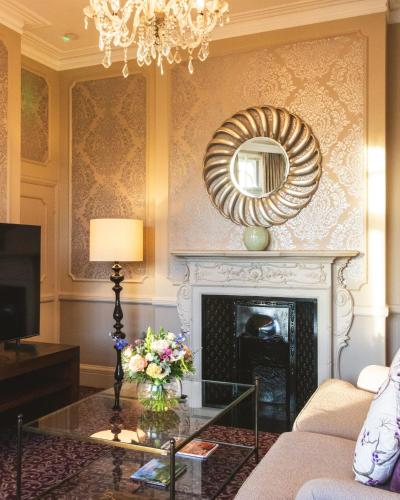 a living room with a fireplace and a mirror at Woodlands Park Hotel in Cobham
