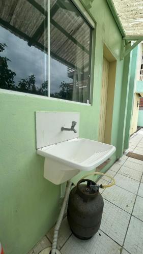 a white sink on a green wall with a window at Residencial Da Cal in Torres