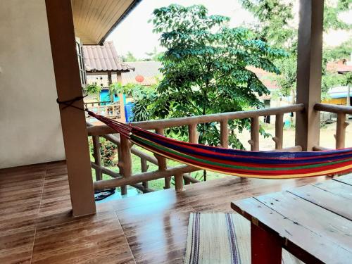 a hammock on a balcony with a view of a yard at Central Essence-200m beachKoh Phangan west coast in Haad Chao Phao