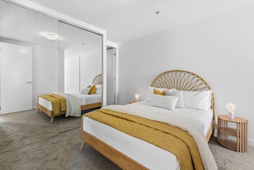 a bedroom with two beds and a large mirror at 2BR Port Melbourne apt - 2 min walk from beach in Melbourne