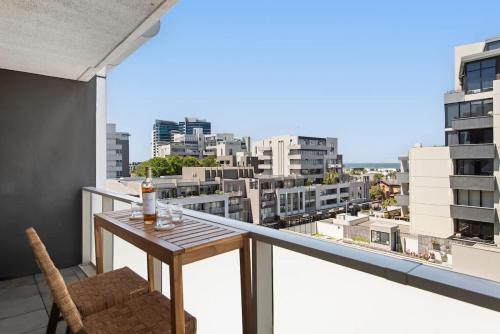 a balcony with a table and a view of a city at 2BR Port Melbourne apt - 2 min walk from beach in Melbourne