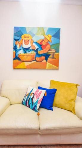 a living room with a couch with a painting on the wall at A House near CR7 Museum Madeira in Funchal