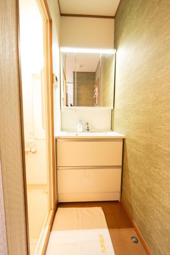 a bathroom with a sink and a mirror at 九洲別苑 in Osaka