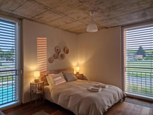 een slaapkamer met een bed met 2 lampen en 2 ramen bij Wonderful cozy apartment very well located in Gross Gurmels