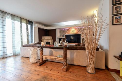 a living room with a couch and a television at Host Monti del Sole in Meano