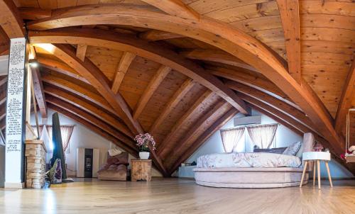 a bedroom with wooden ceilings and a bed in a room at Host Monti del Sole in Meano