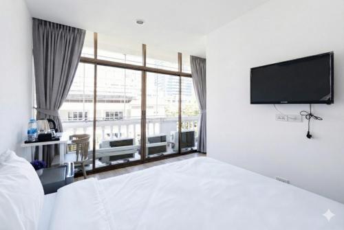 ein Schlafzimmer mit Bett und Flachbildfernseher in der Unterkunft Rest Inn Silom - เรสท์ อินน์ สีลม in Bang Rak
