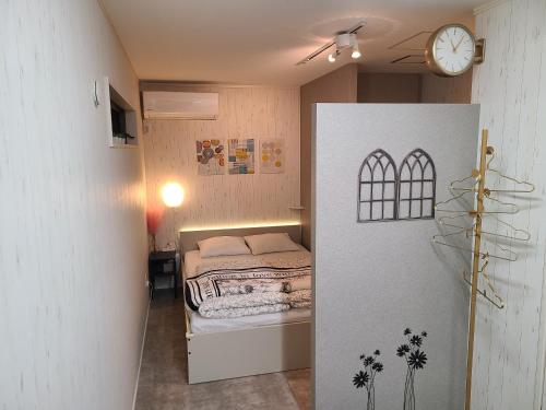 a bedroom with a bed and a clock on the wall at Greci Art Tokyo-Kinshicho Area Private room- in Tokyo