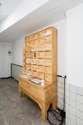 a room with a wooden wall with a desk at Rest Inn Silom Bangkok in Bang Rak