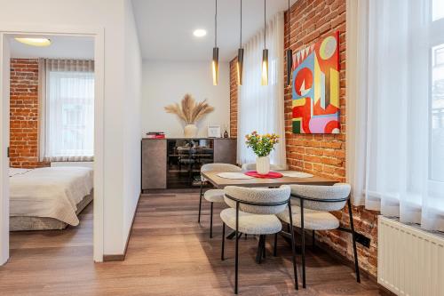 ein Zimmer mit Tisch und Stühlen und ein Schlafzimmer in der Unterkunft Center Gallery Apartment in Kaunas