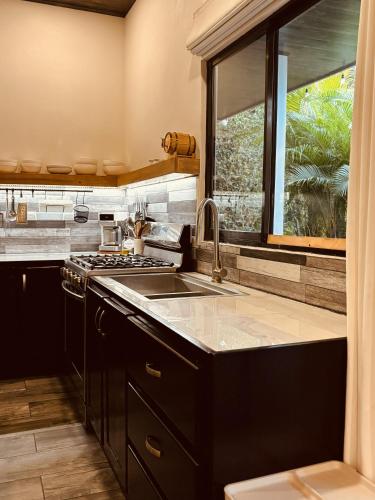 a kitchen with a sink and a stove and a window at Hotel Daleese in Uvita
