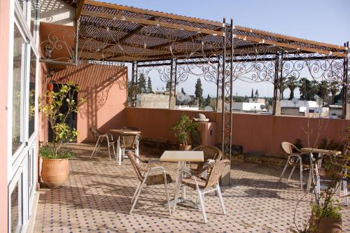 a patio with tables and chairs on a building at Hotel Bab Boujloud in Fès