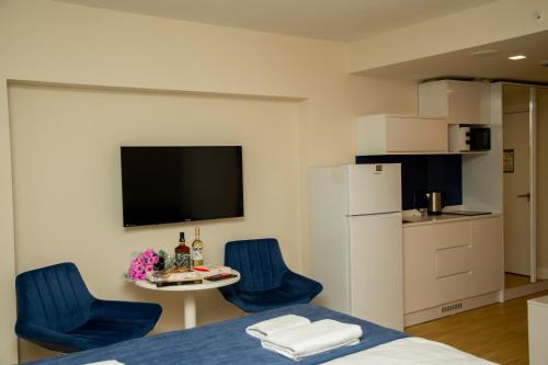 Orbi city Aparthotel في باتومي: غرفة بسرير وكرسيين ازرق وطاولة