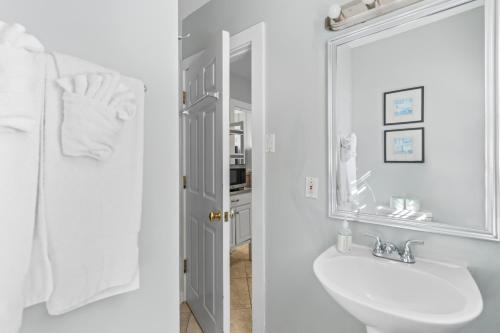 een witte badkamer met een wastafel en een spiegel bij Prime Downtown Location - Truman Little Cozy Cottage in Key West