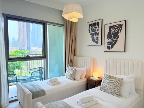 a hotel room with two beds and a window at Private Room in Luxury Burj Vista Apartment Dubai with Burj Khalifa View Near Dubai Mall in Dubai
