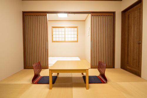 a room with a table and two chairs and a bed at 九洲別苑 in Osaka