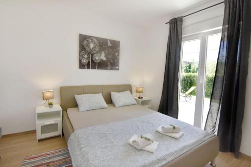a bedroom with a bed with two towels on it at Relaxing holiday home with shared pool in Čepljani
