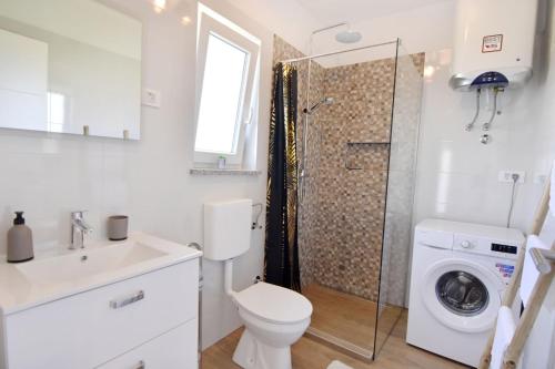 a bathroom with a toilet a sink and a shower at Relaxing holiday home with shared pool in Čepljani