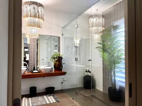 a bathroom with a glass shower and a sink at BIG Beach House Tranquility in Kewarra Beach