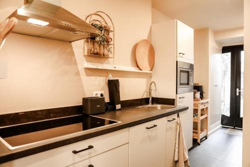 a kitchen with white cabinets and a sink at Cityloft in Breda VP092 in Breda