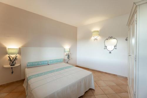 een slaapkamer met een bed en twee lampen aan de muur bij Cozy accommodation with shared pool in Vignola Mare
