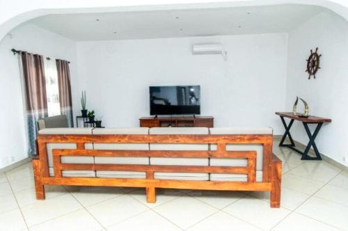 een woonkamer met een bank en een flatscreen-tv bij Maison avec Jardin à la Pyrot in Diego Suarez