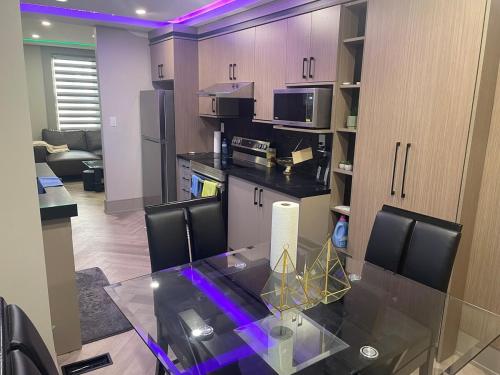 a kitchen with a glass table in a room at Modern 7 Bedroom Masterpiece on Portage Sleeps 16 in Niagara Falls
