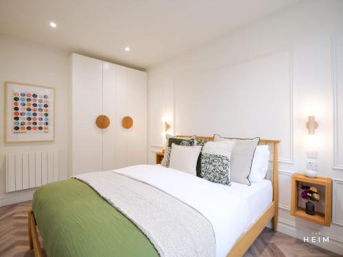 a bedroom with a large white bed with pillows at Calico at The Heim Residences in Manchester
