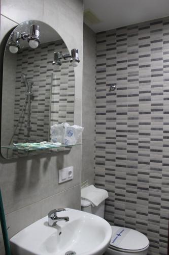 a bathroom with a sink and a toilet and a mirror at Apartamentos Bolonia Paraiso in Bolonia