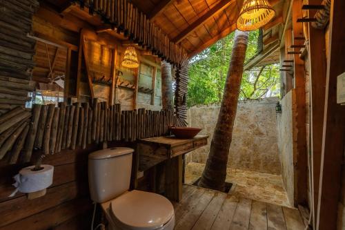 een badkamer met toilet in een houten huis bij CasaCoral Hotel in Puerto Limón
