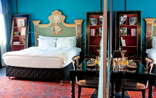 een slaapkamer met een bed met een blauwe muur bij Alma Boutique Hotel & Lounge in Tel Aviv
