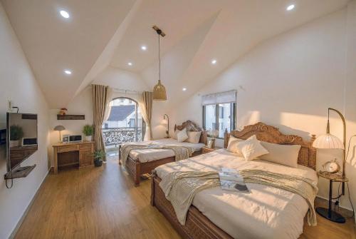 a bedroom with two beds and a living room at Le'Mon in Da Lat