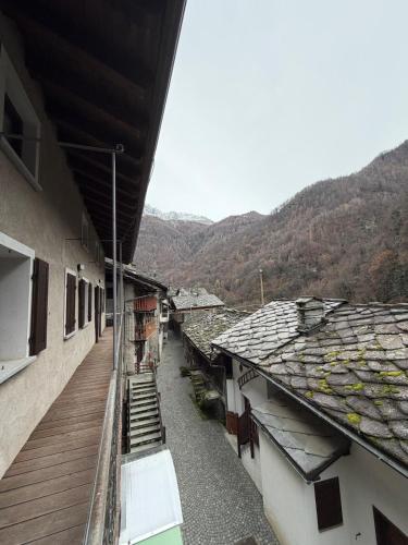 einen Balkon eines Gebäudes mit Bergen im Hintergrund in der Unterkunft La Cantina del Sole in Pontboset