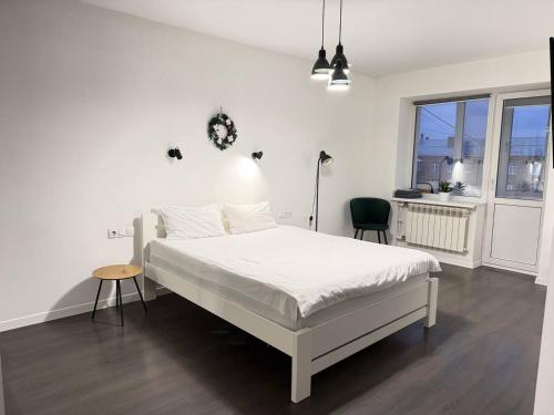 a white bedroom with a white bed and a window at White Apartment in Poltava