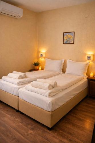 een groot wit bed in een kamer met 2 lampen bij Хотел Ривърсайд Анекс in Bansko