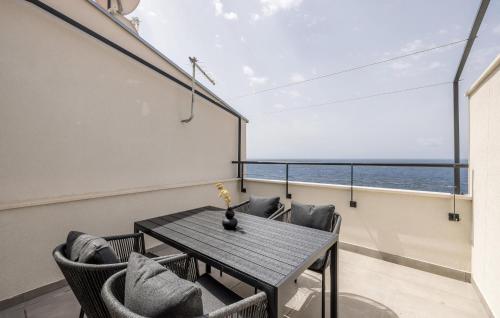 a table and chairs in a room with a view of the ocean at Cozy Apartment In Potomje With Lake View in Potomje
