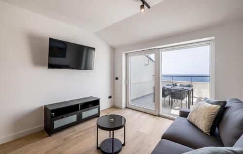 a living room with a couch and a view of the ocean at Cozy Apartment In Potomje With Lake View in Potomje