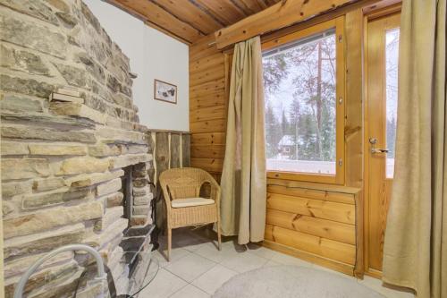 a room with a stone fireplace and a window at Pyhäkoti D - 30 Meters From the Slopes in Pyhätunturi