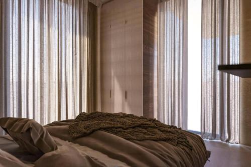 een bed in een slaapkamer met gordijnen en een raam bij Villa Kalymnos by Villa Plus in Kolimbia