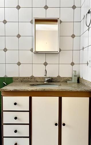 a bathroom with a sink and a mirror at No centro da cidade 750m da universidade in Viçosa