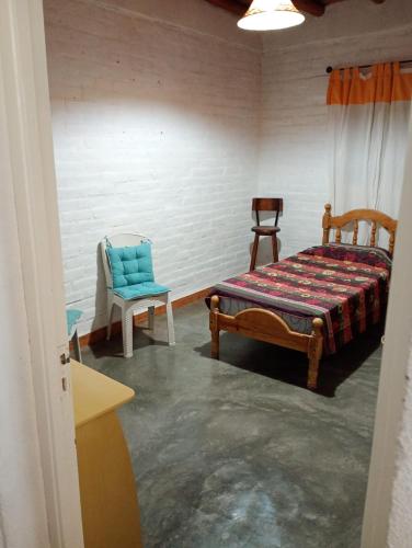 een slaapkamer met een bed en 2 stoelen. bij Casa Cómoda en Barreal in Barreal