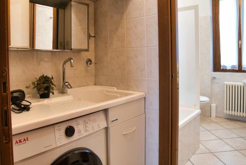 a bathroom with a washing machine and a sink at Cassina Lavallee 8 in Cremeno