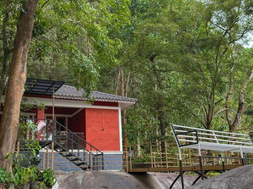 a red house with a staircase leading to it at Rockviewstay in Kalpetta